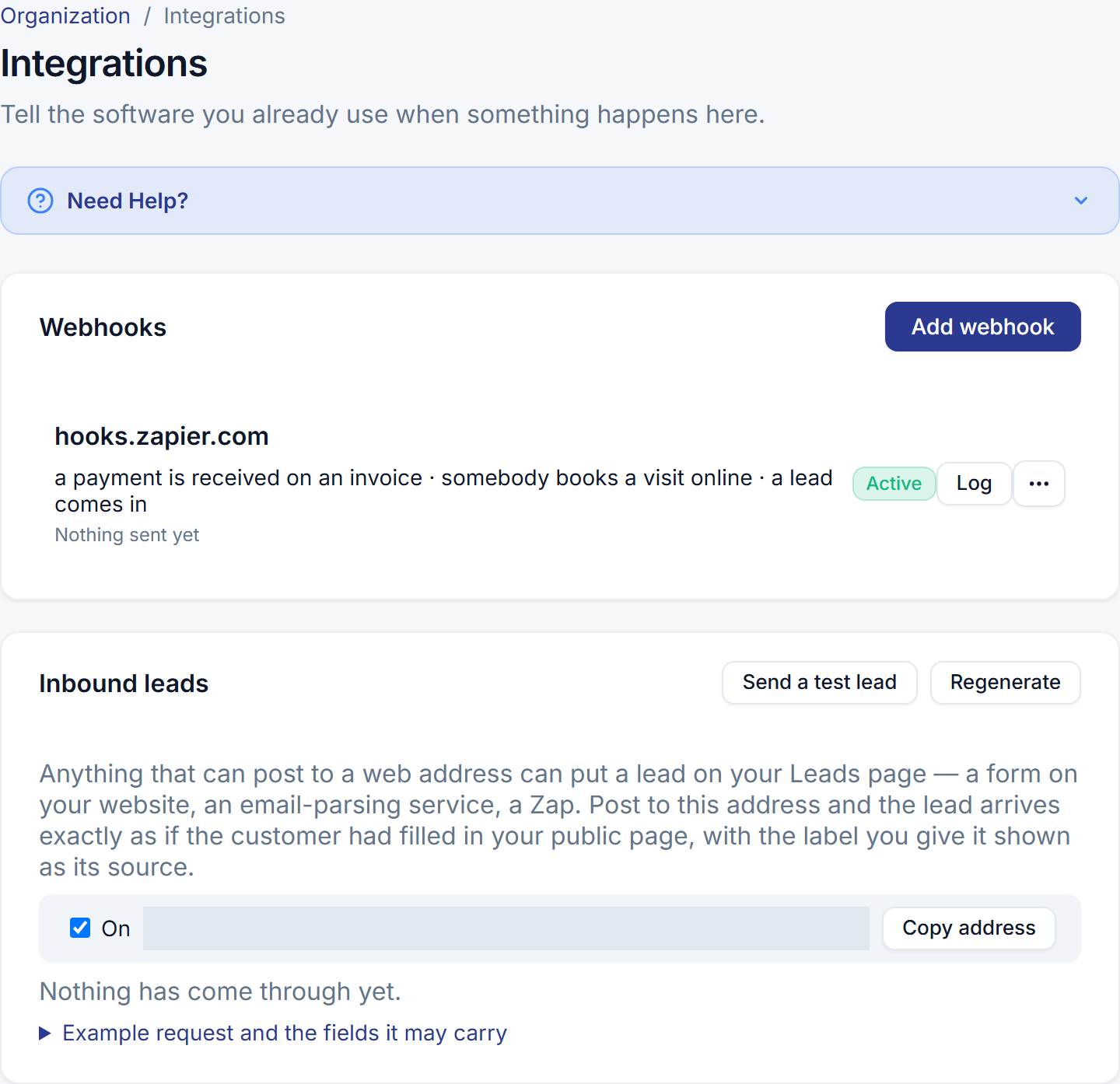 The Integrations page: one webhook to hooks.zapier.com listed with the events it carries — a payment is received on an invoice, somebody books a visit online, a lead comes in — and Active beside it; beneath, the Inbound leads card with the business's own address, a Copy button, the switch On, and a line saying nothing has come through yet.